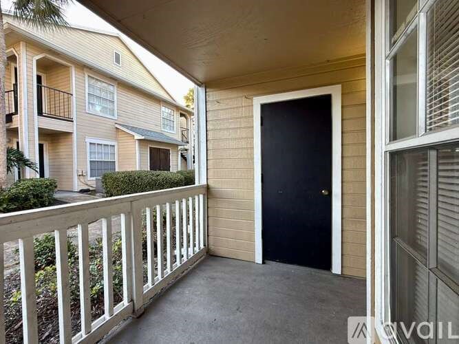 A balcony with a black door and white railings.