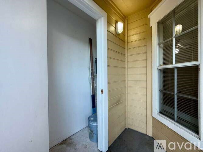 A broom is leaning against a wall next to a door.
