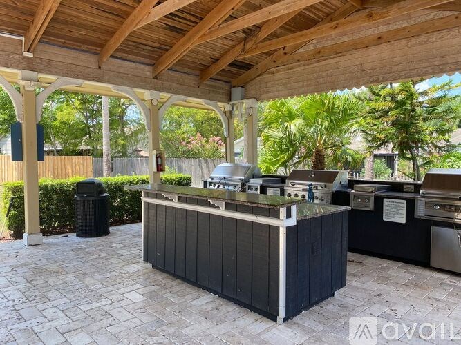 A covered outdoor kitchen area with a grill and sink.
