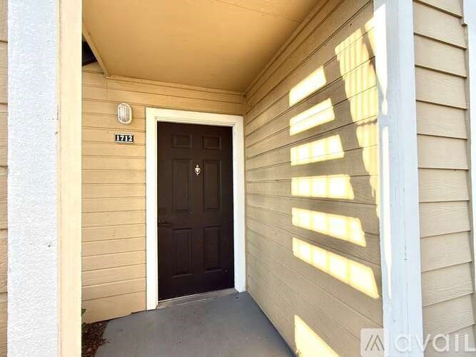 A black door is on the right side of a white wall.