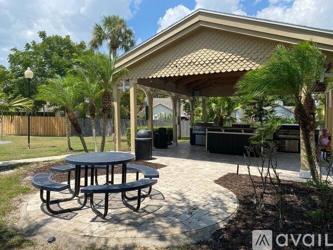A patio with a table and chairs under a roof.