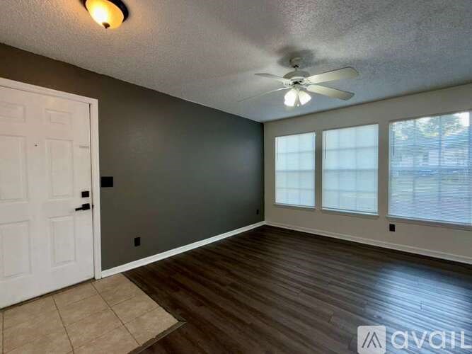 A room with a ceiling fan and sliding glass doors.