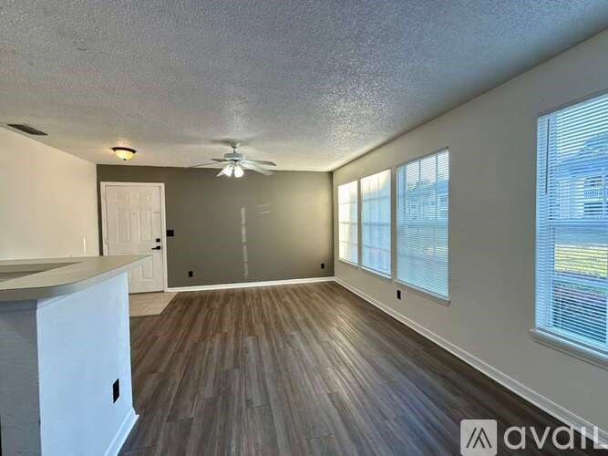 A room with a ceiling fan and wooden flooring.