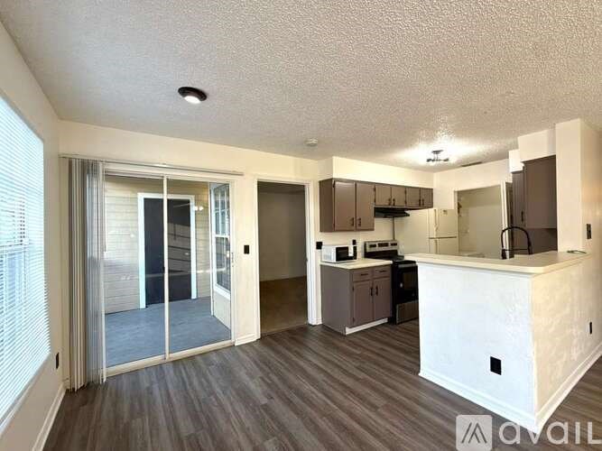 A kitchen area with a sink, stove, and cabinets.
