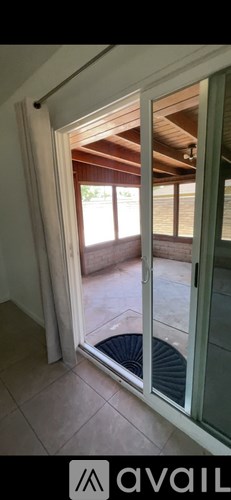 A room with a tiled floor and a window leading to a balcony.