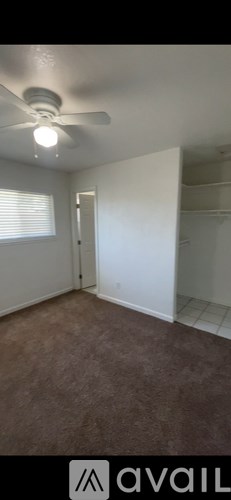 A room with a ceiling fan and carpeted floor.