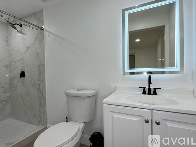 A white toilet sits next to a sink in a bathroom.