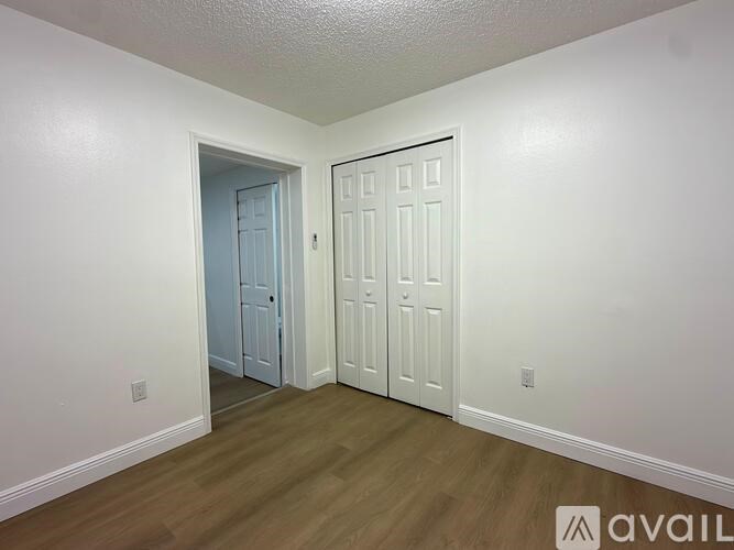 A room with a white door and a blue door in the background.