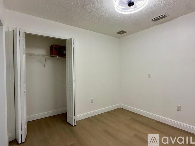 A small closet with a white door is open.