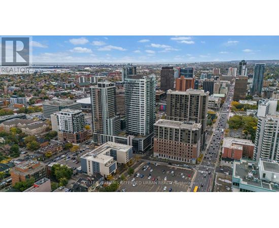 A cityscape with a mix of modern and older buildings, with a clear sky above.