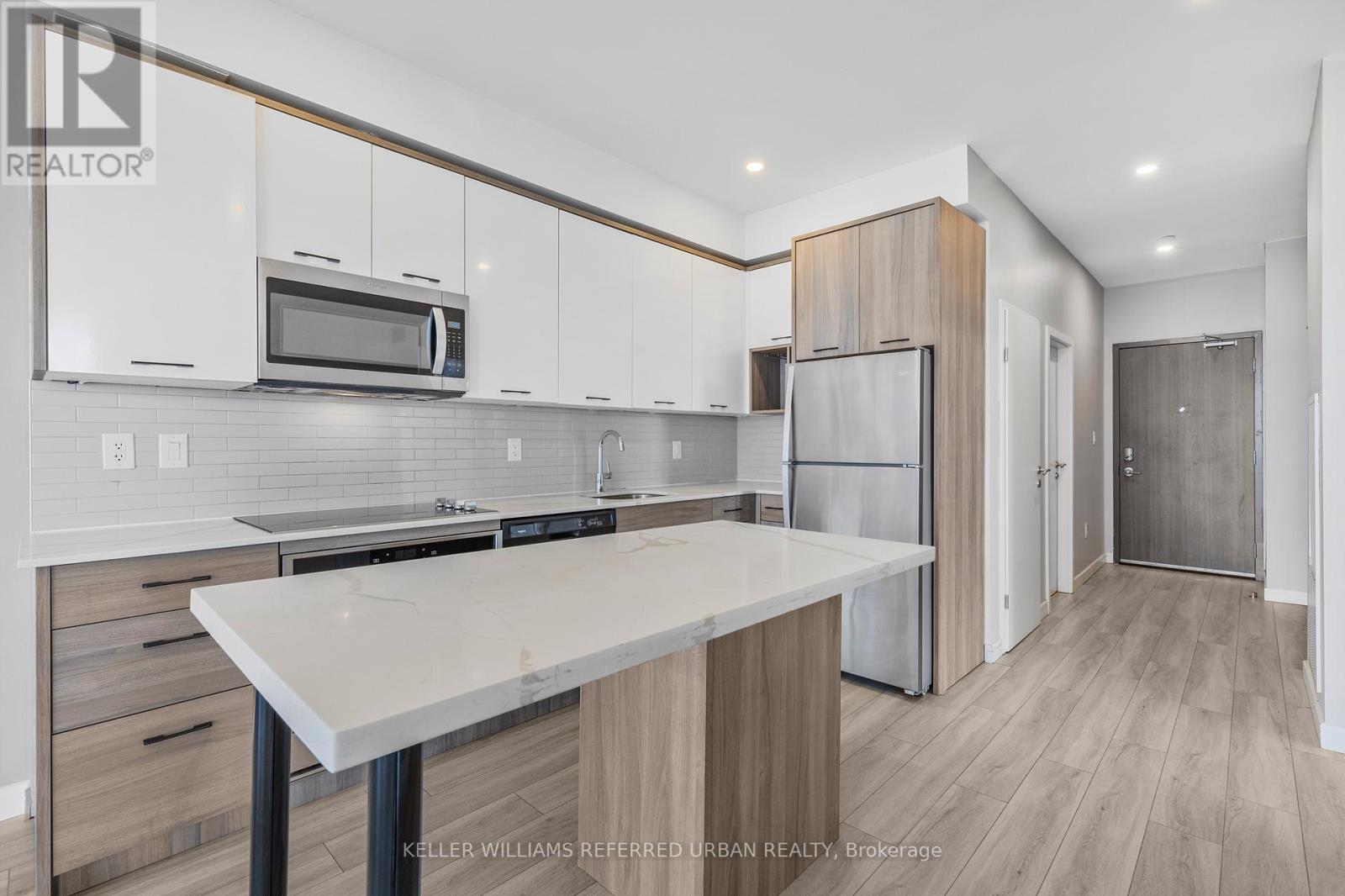A modern kitchen with white cabinets and a central island.