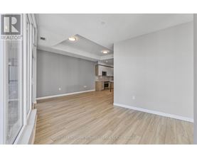 A spacious room with wooden flooring and white walls.