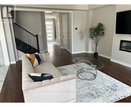 A living room with a white couch and a glass coffee table.