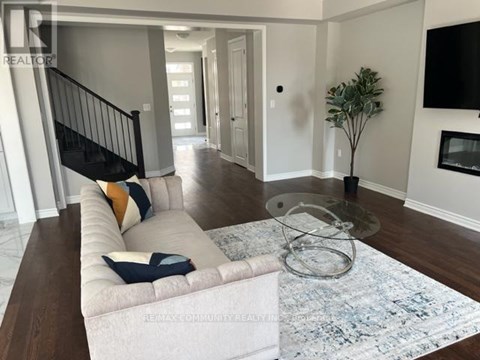 A living room with a white couch and a glass coffee table.