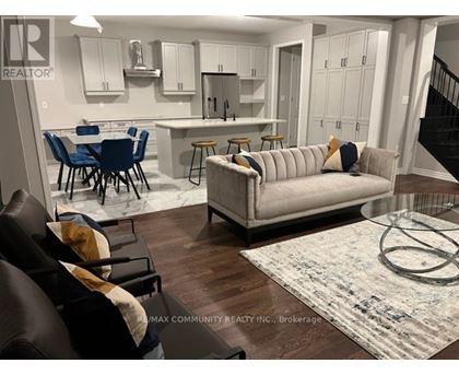 A living room with a couch, chairs, and a dining table.
