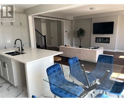 A modern kitchen with blue chairs and a white countertop.