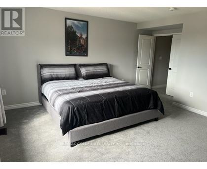 A bedroom with a large bed and a painting on the wall.