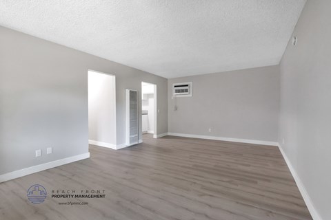 the spacious living room with hardwood flooring and white walls