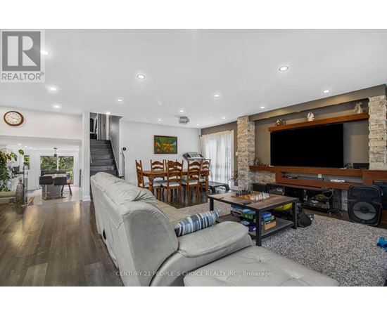 A living room with a grey sofa and a wooden entertainment center.