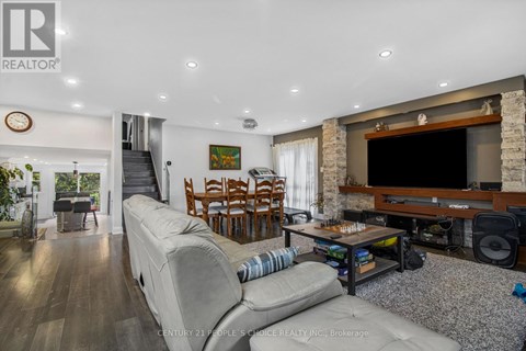 A living room with a grey sofa and a wooden entertainment center.