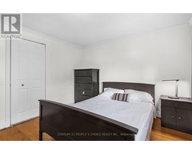 A bedroom with a bed, nightstand, and a cabinet.