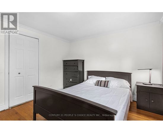 A bedroom with a bed, nightstand, and a cabinet.