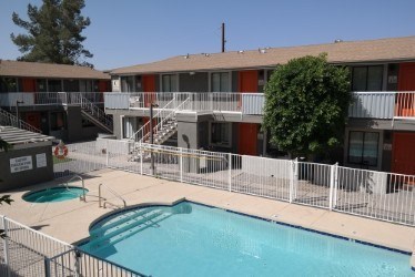 A pool in a courtyard surrounded by apartment buildings.