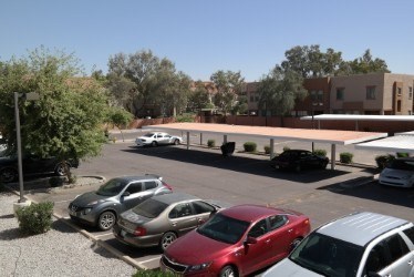 A parking lot with cars and a building in the background.