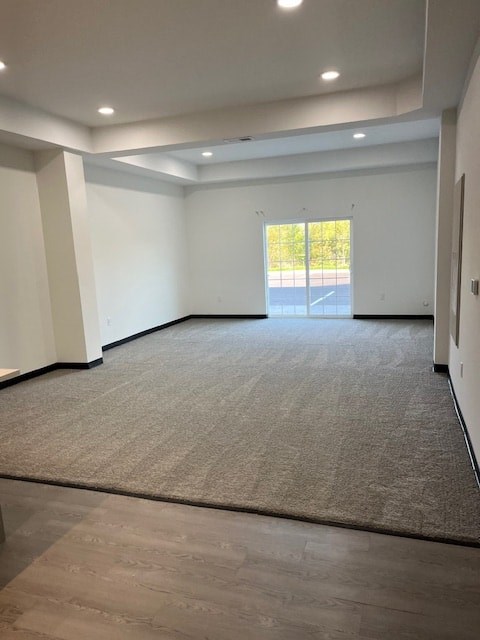 A spacious room with a carpeted floor and a window.