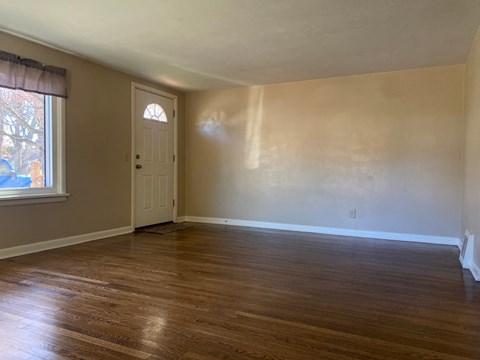 A room with wooden flooring and a white door.