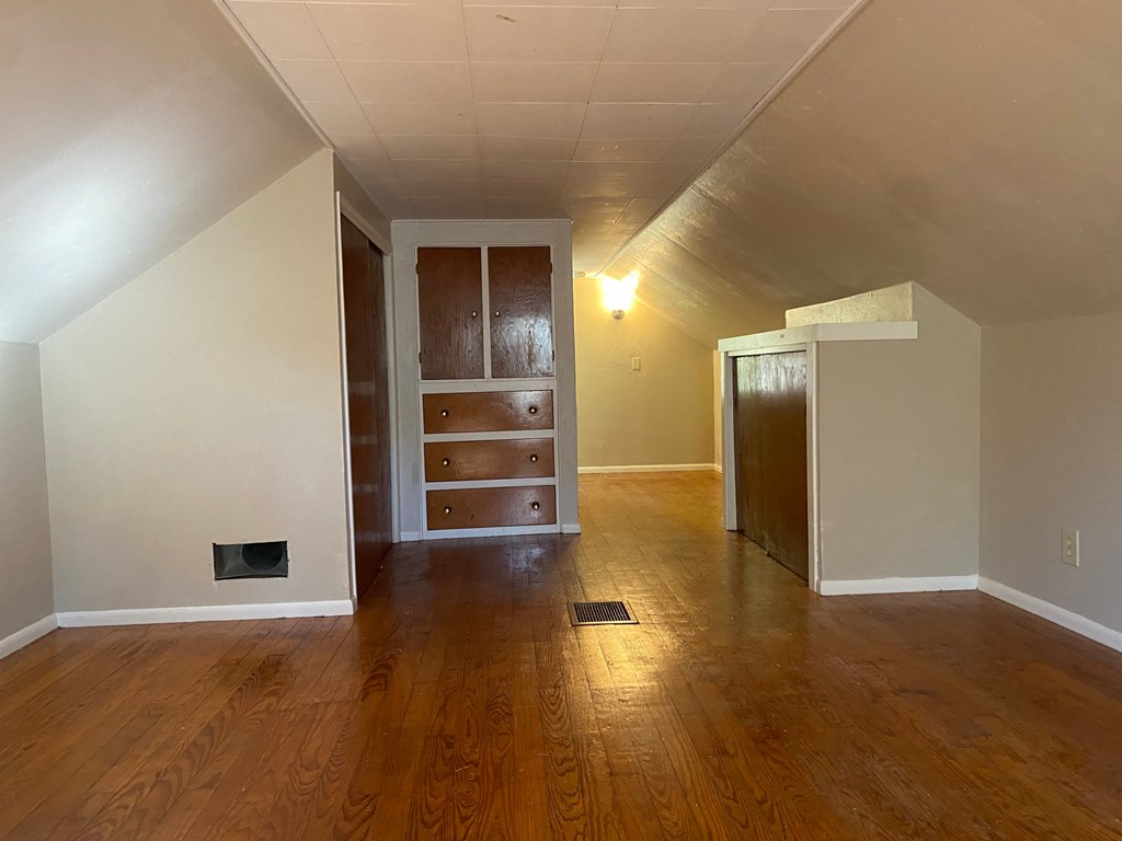 A room with wooden floors and a fireplace.