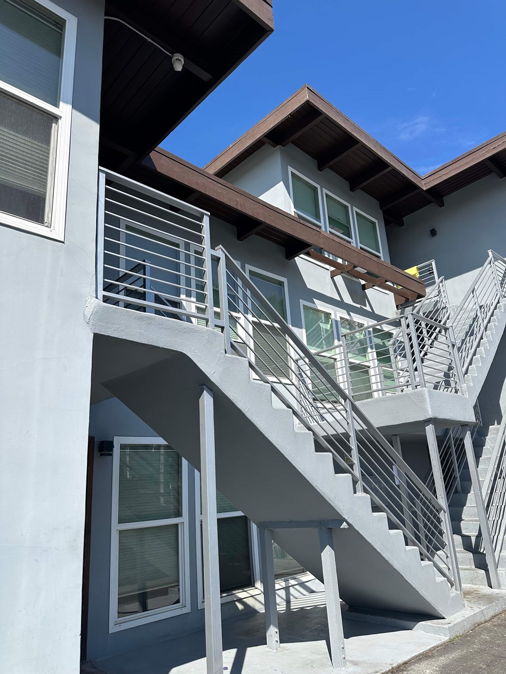 A staircase with a metal railing leads up to a balcony.