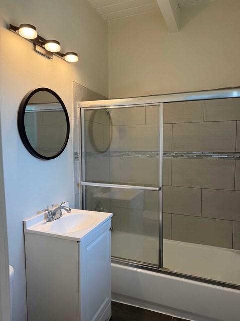A bathroom with a white sink and a mirror above it.