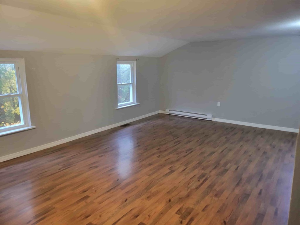 A room with wooden flooring and a window.