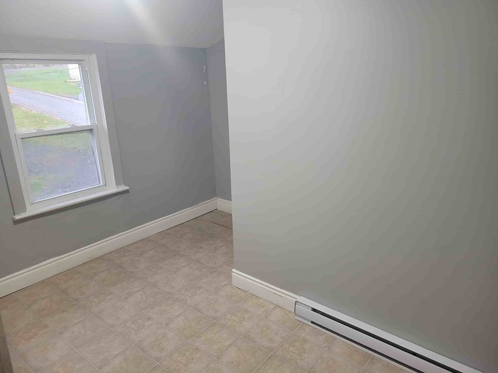 A room with a window and tiled floor.