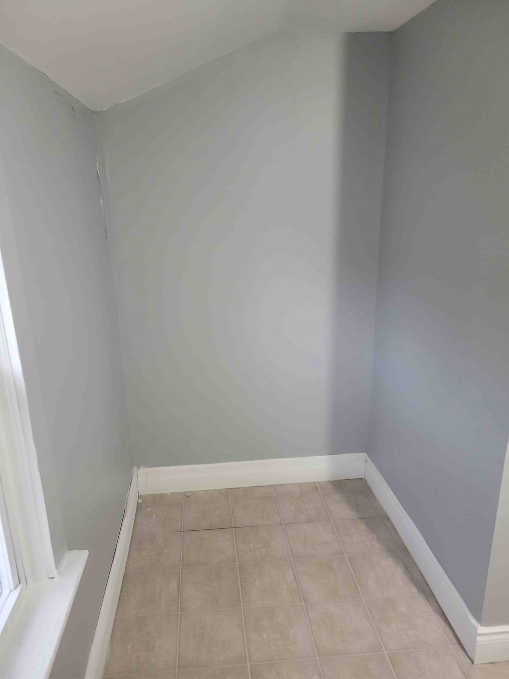 A corner of a room with a tiled floor and white walls.