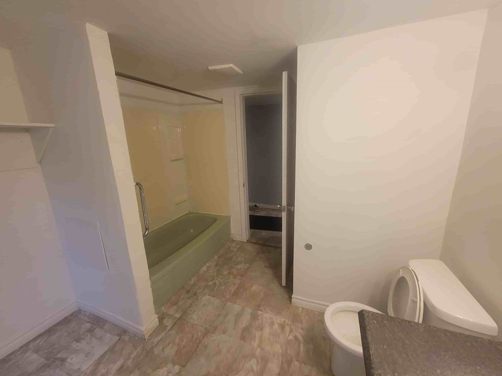 A bathroom with a toilet, sink, and bathtub.