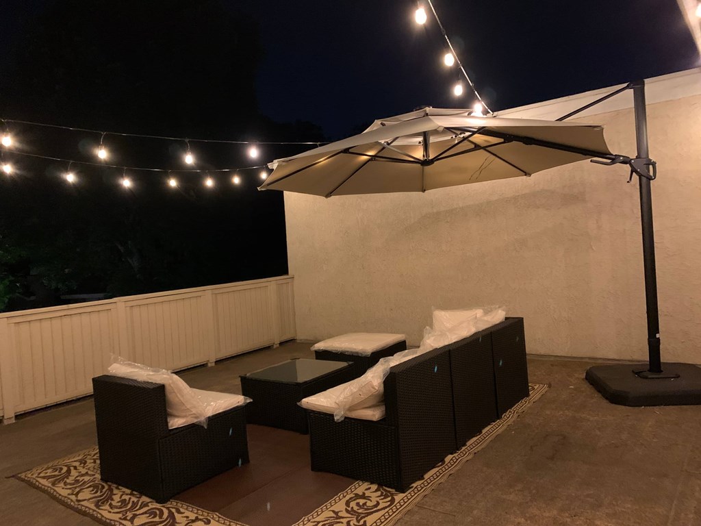 A patio with a table and chairs under a canopy.