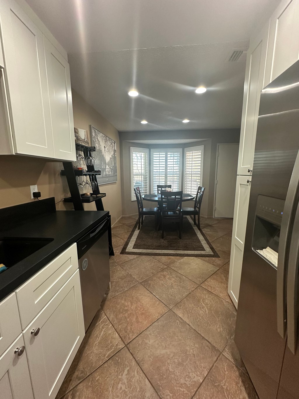 A kitchen with black countertops and white cabinets.