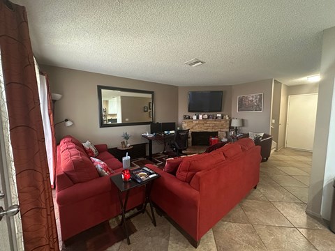 A living room with red couches and a television.