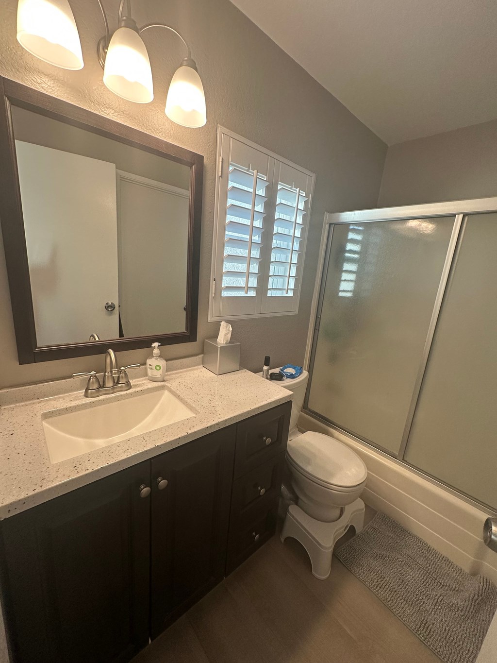 A bathroom with a sink, toilet, and shower.