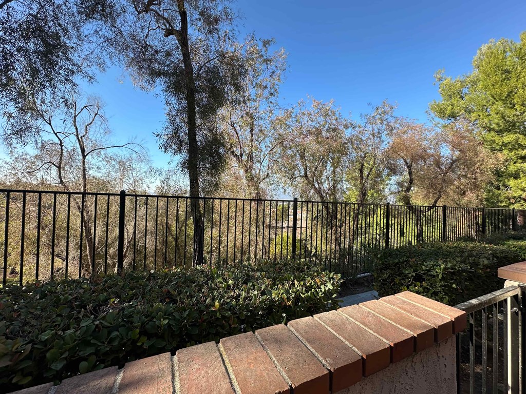 A black metal fence surrounds a brick wall.