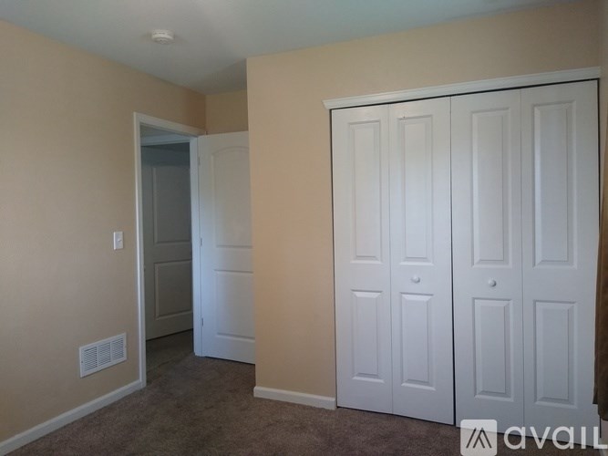 A room with a carpeted floor and a white door.