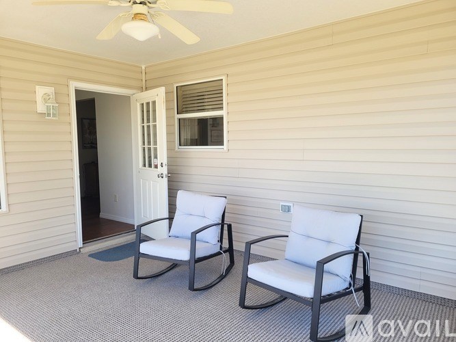 Two chairs are placed on a carpet in a room with a ceiling fan.