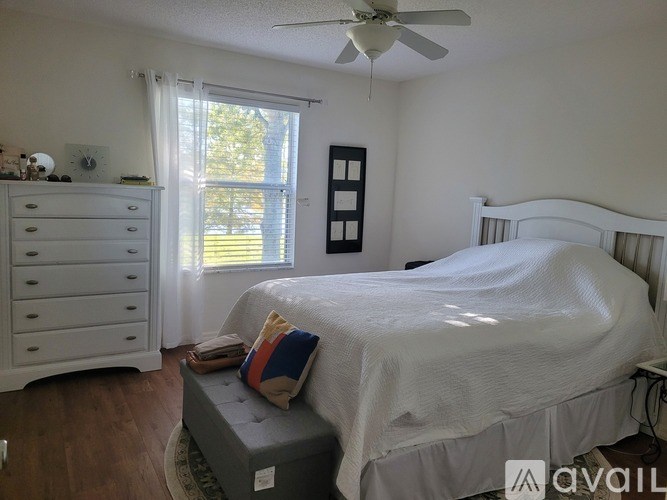 A bedroom with a bed, dresser, and window.