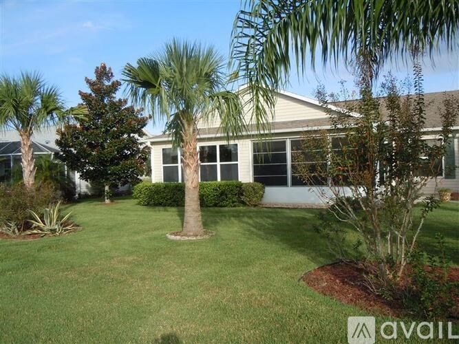 A house with a lawn and trees in front of it.