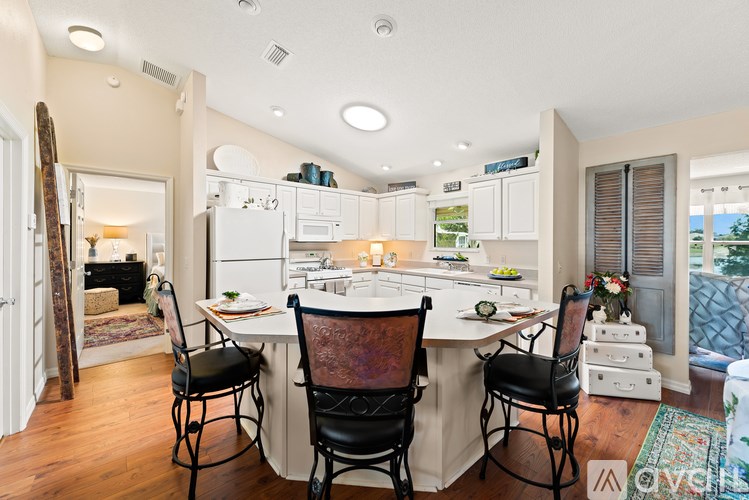 A kitchen with a table and chairs in front of it.