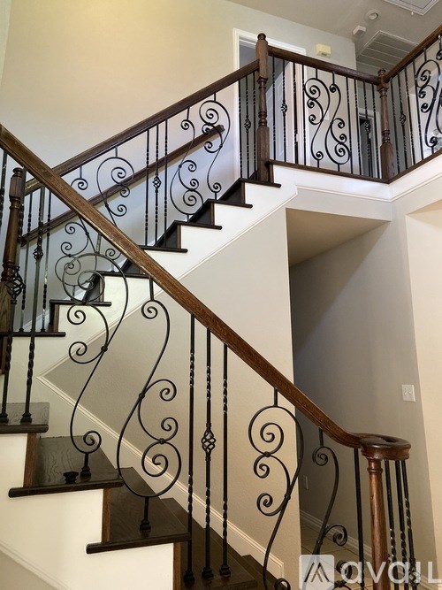 A staircase with a metal railing and wooden handrails.
