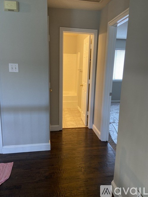 A hallway with a doorway leading to another room.
