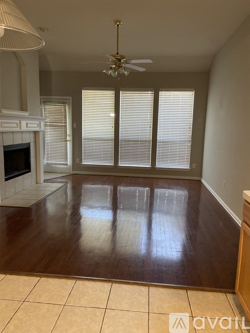 A living room with a fireplace and a fan.